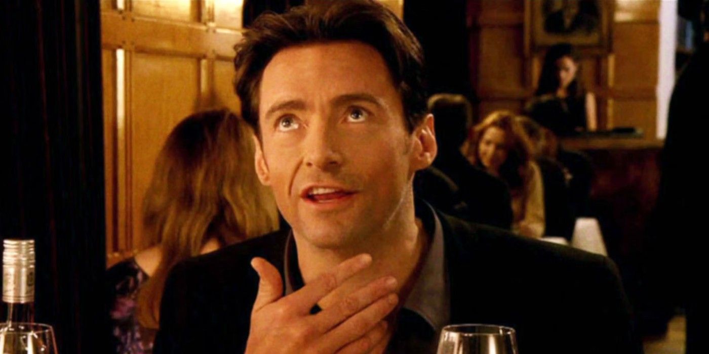 Hugh Jackman looking up while holding his hand up in Movie 43