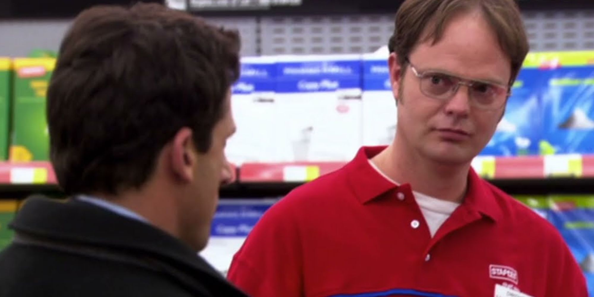 Rainn Wilson em um uniforme da Staples como Dwight Schrute conversando com Steve Carell como Michael Scott em The Office