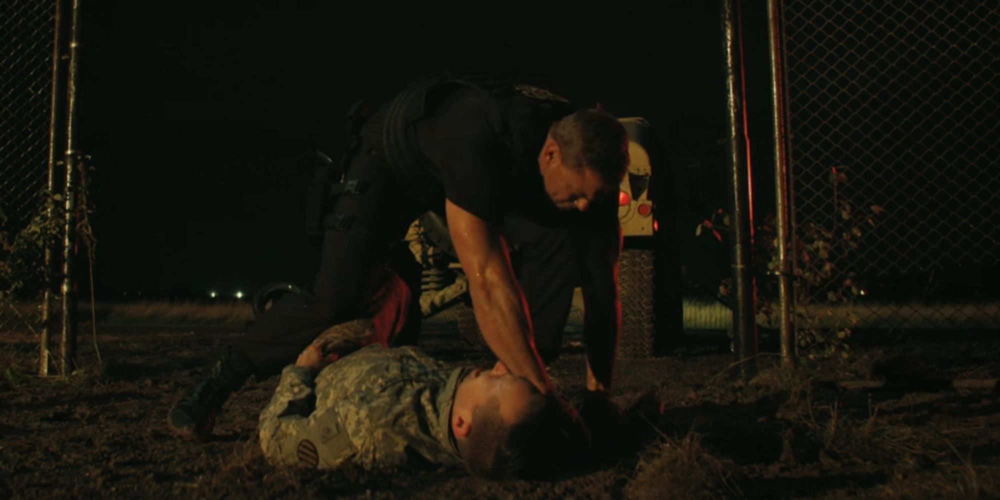 Alan Ritchson as Reacher arresting a man in military attire who is lying on the ground