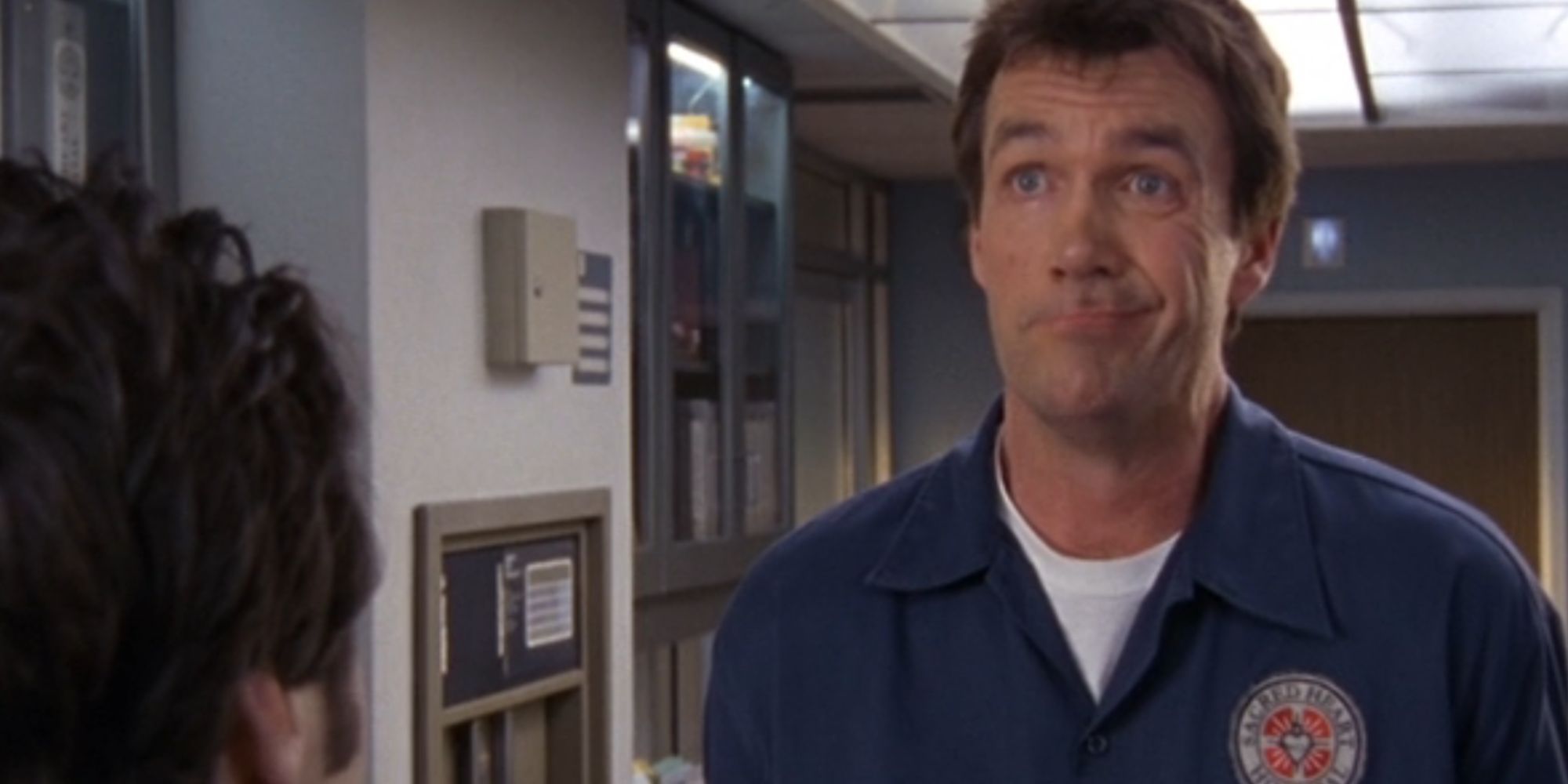 Neil Flynn como o zelador fazendo uma careta engraçada em Scrubs