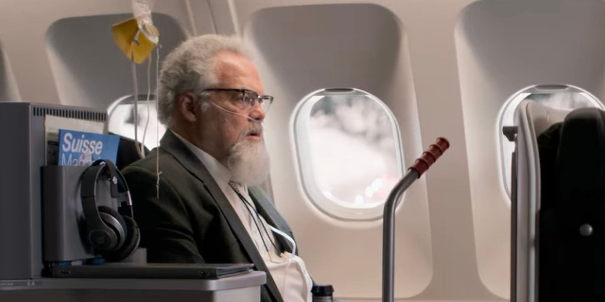 Vincent D'Onofrio dressed as an old man and sitting on a plane in Lift