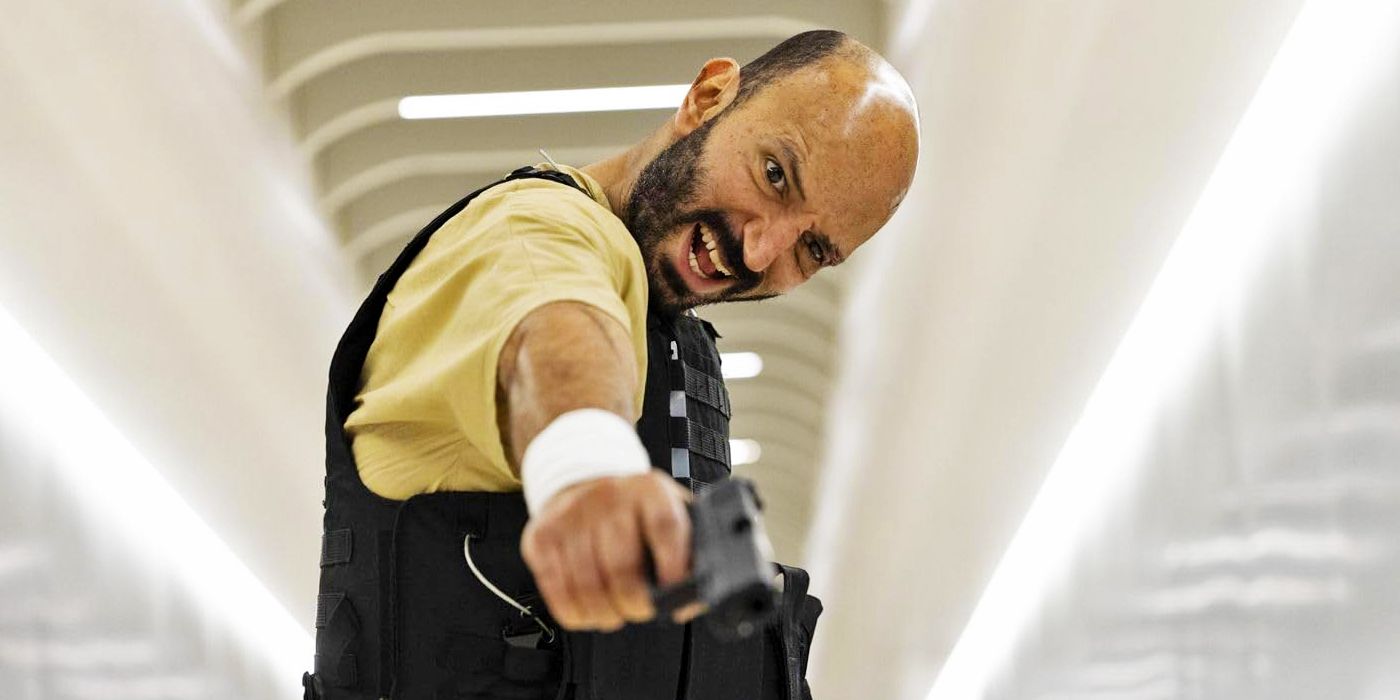 Waleed Elgadi como Amin Mansur segurando uma arma de lado apontando para baixo em One More Shot 2024