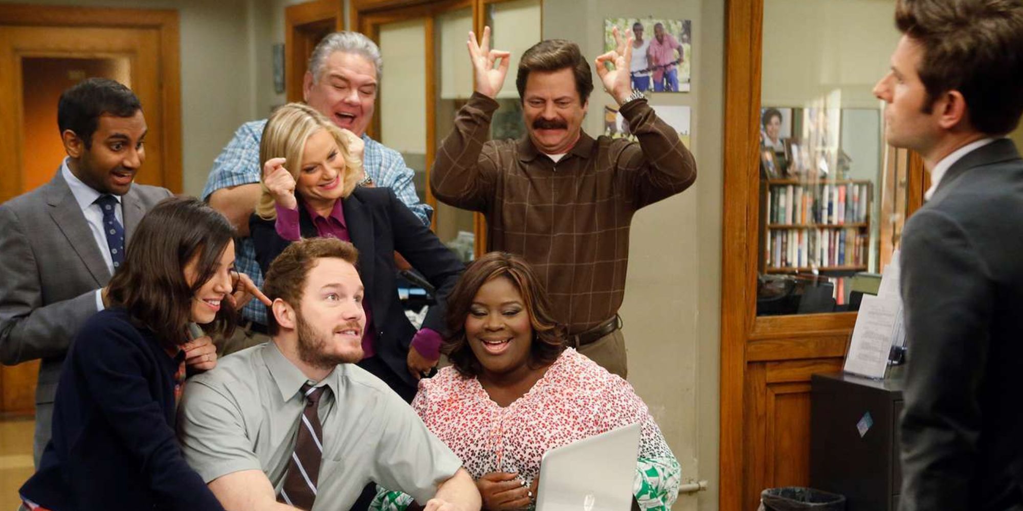 The cast of Parks and Recreation celebrating in their office