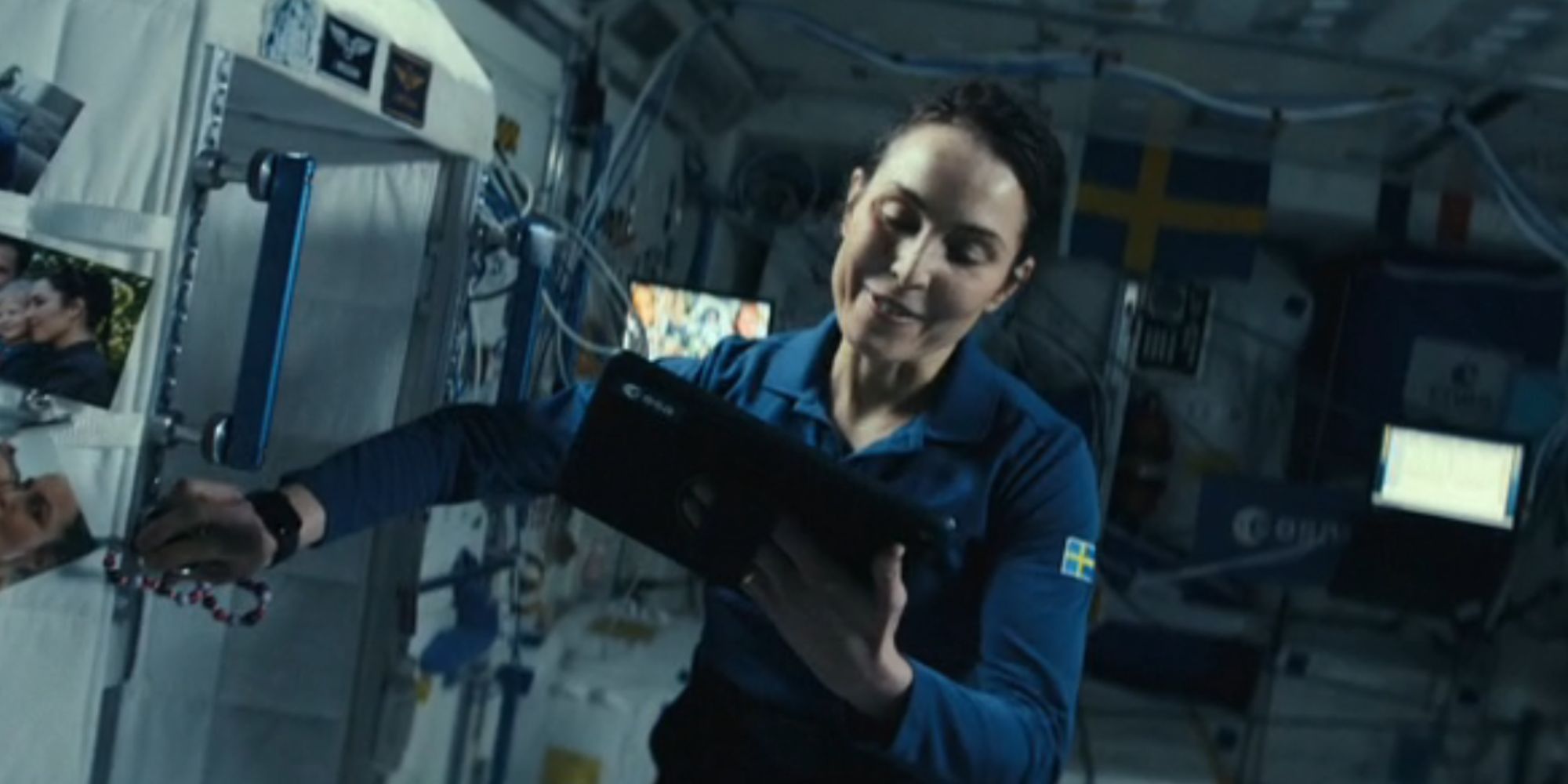 Noomi Rapace as Jo on the International Space station smiling at an iPad in Constellation - The ISS scenes could be set in the same universe as Jo's funeral - Jo's First Reality Is Shown In Constellation's First Episode