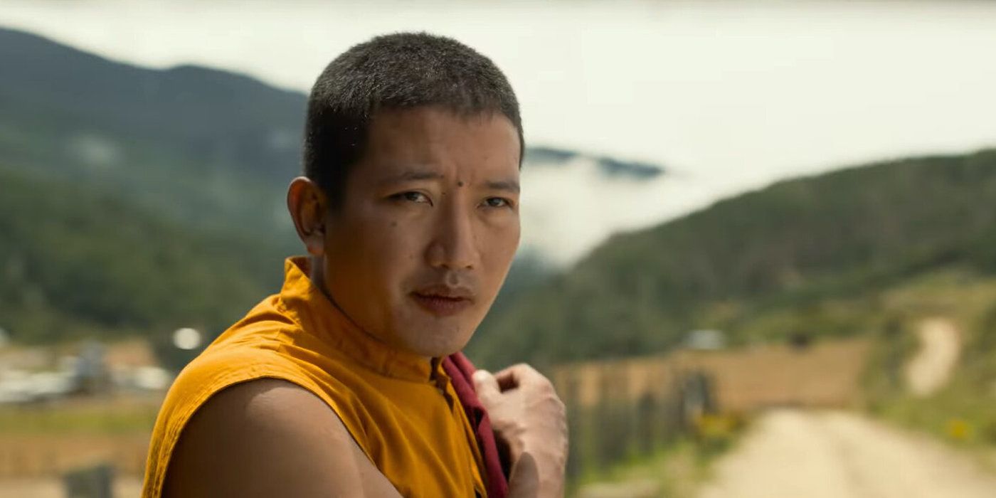 the monk stands with one arm crossing his shoulder