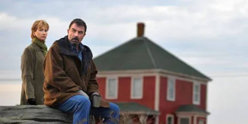 Jesse Stone sitting on a pier with a woman behind him