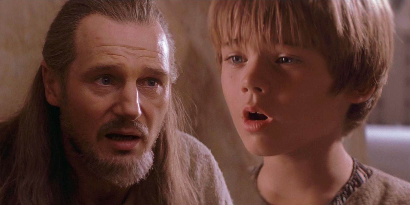 Young Anakin Skywalker looking surprised to the right and Qui-Gon Jinn looking surprised to the left.