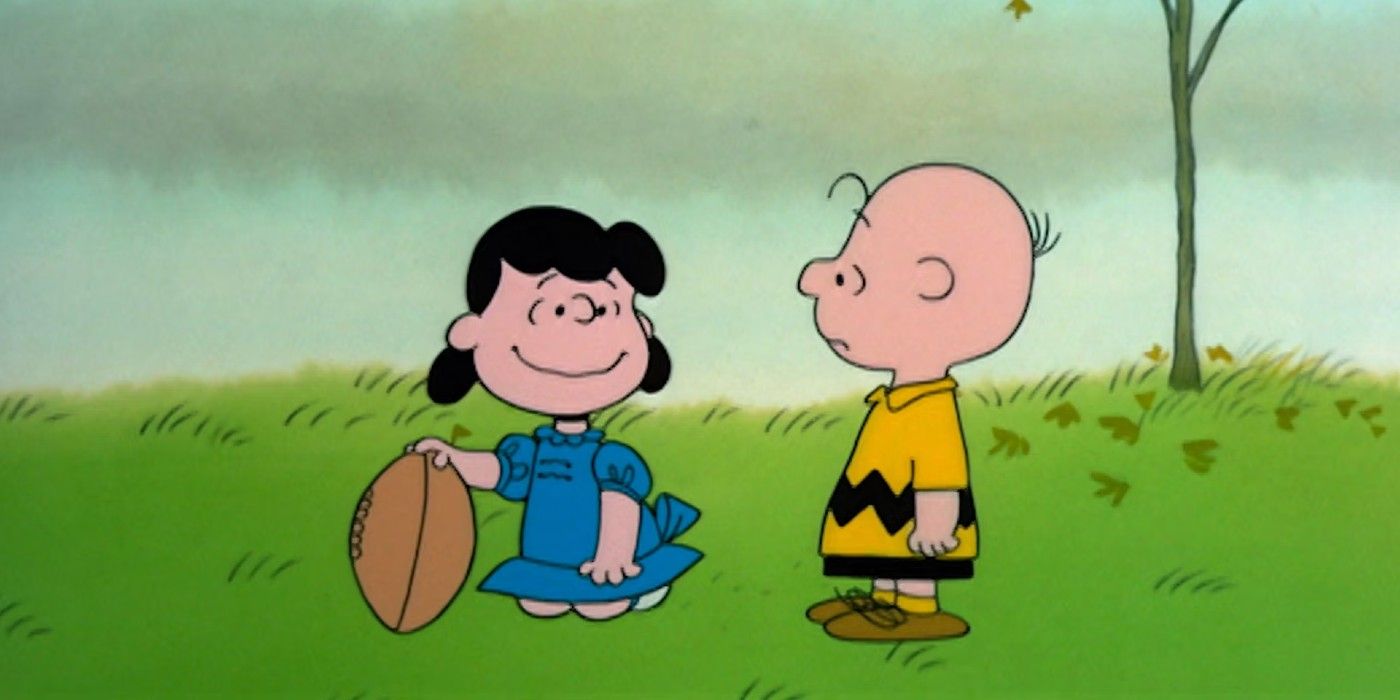 Lucy van Pelt holding a football while Charlie Brown stands beside her
