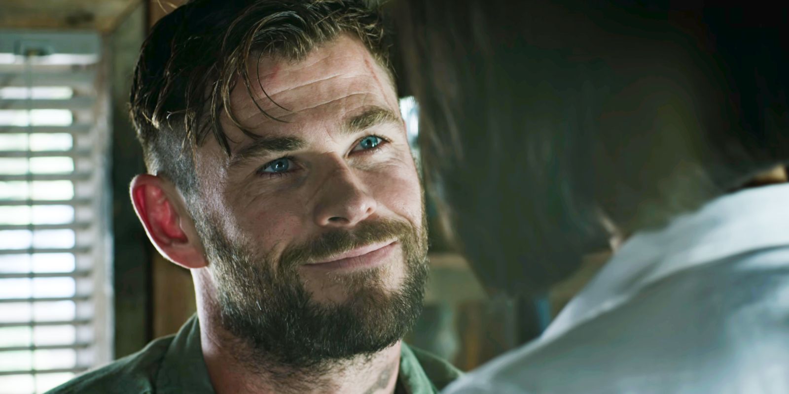 Chris Hemsworth's Tyler Rake smiling up at Nik in Extraction