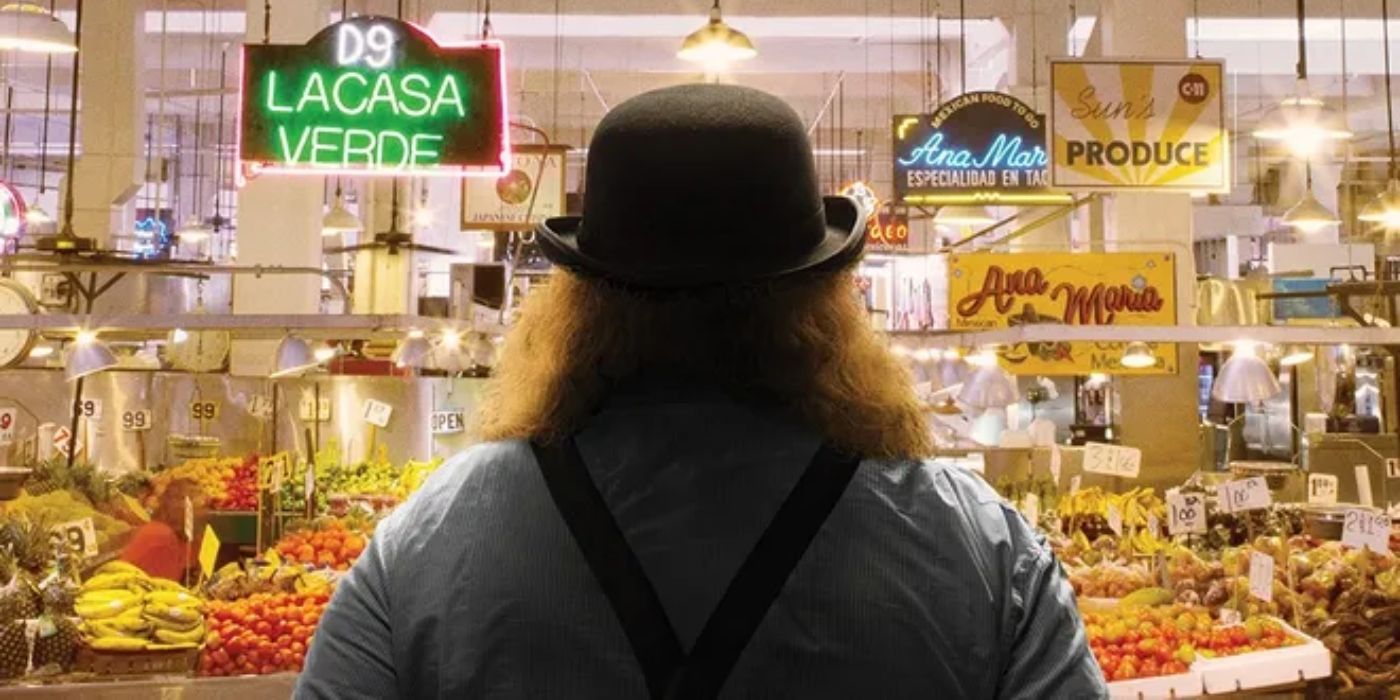 Um homem virado de costas em um mercado de alimentos na Cidade do Ouro