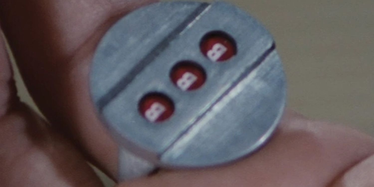 Closeup of Q's (Desmond Llewelyn) hand wearing the electromagnetic rpm slot machine controller ring in Diamonds are Forever.