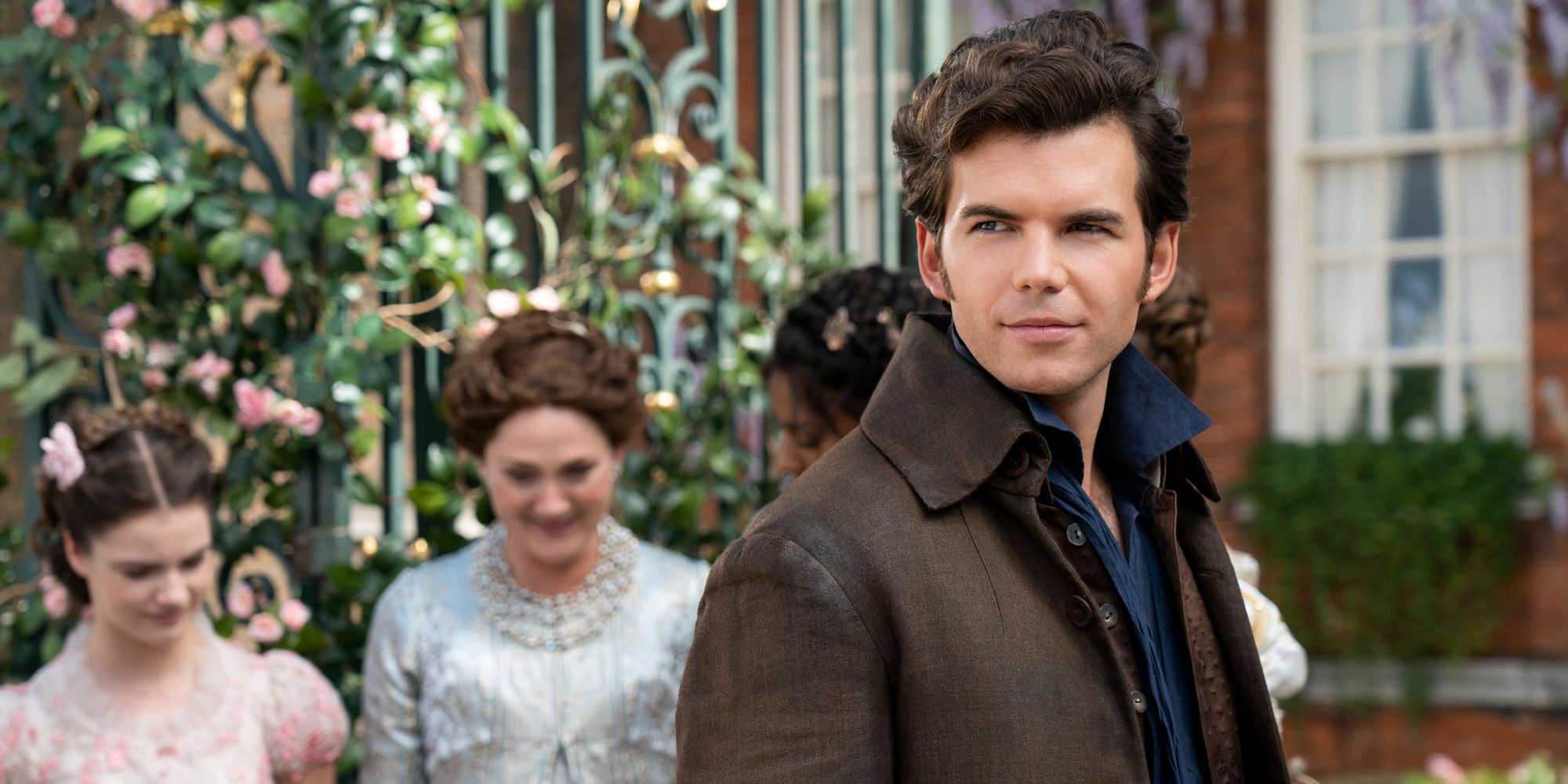 Colin stands in front of his family home in Bridgerton season 3