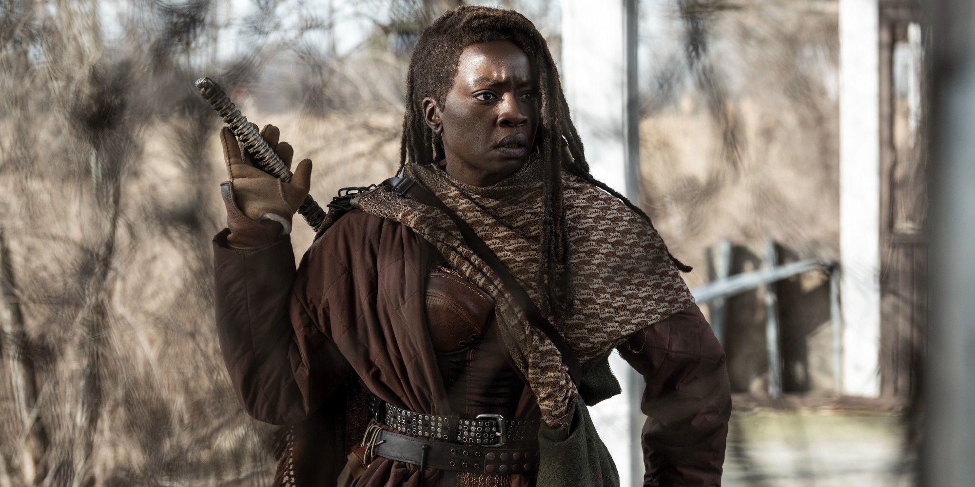 Danai Gurira como Michonne em The Walking Dead The Ones Who Live alcançando suas costas em busca de sua espada