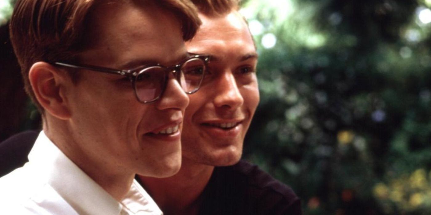 Dickie Greenleaf (Jude Law) with his arms around Tom Ripley (Matt Damon), both men smiling in The Talented Mr Ripley-1