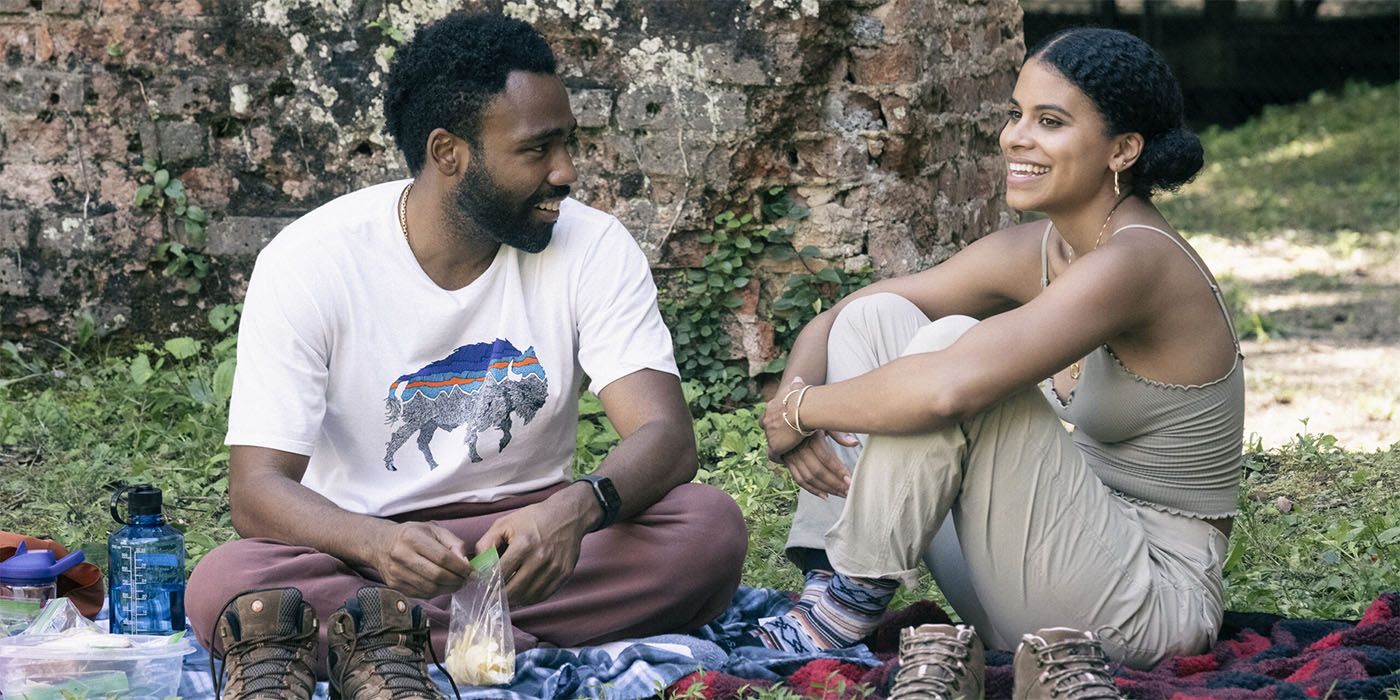 Donald Glover as Earn and Zazie Beetz as Van sitting on the grass laughing in Atlanta season 4 episode 7