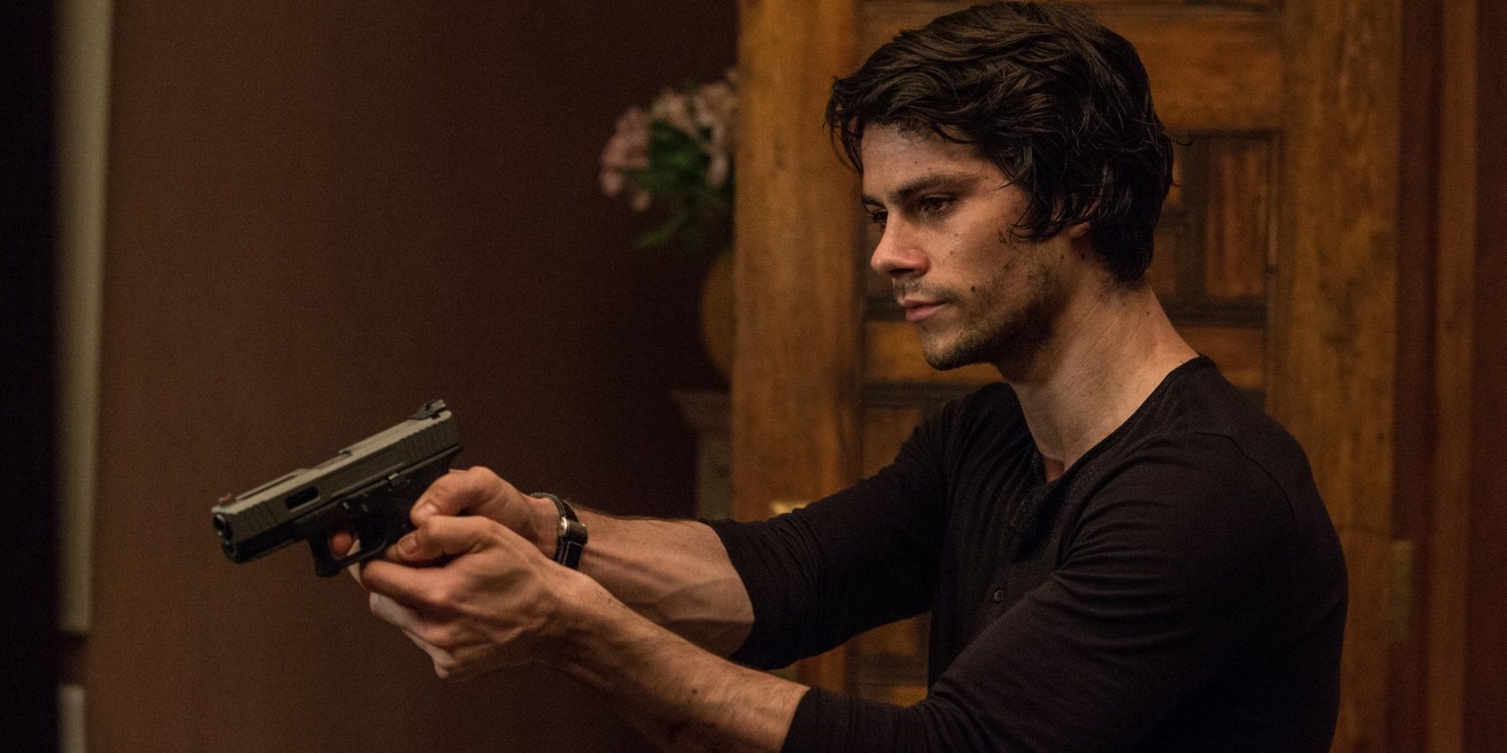 Dylan O'Brien with a gun in American Assassin