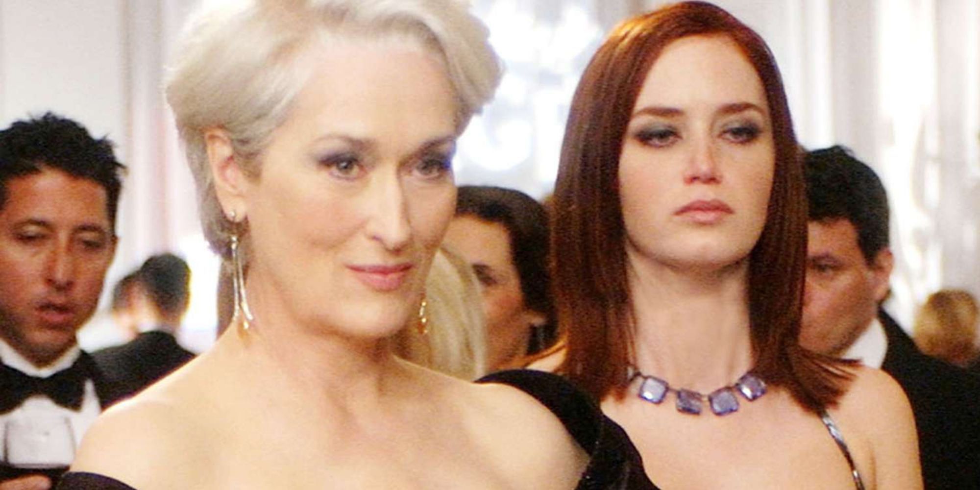 Emily Blunt e Meryl Streep em pé uma ao lado da outra em O Diabo Veste Prada
