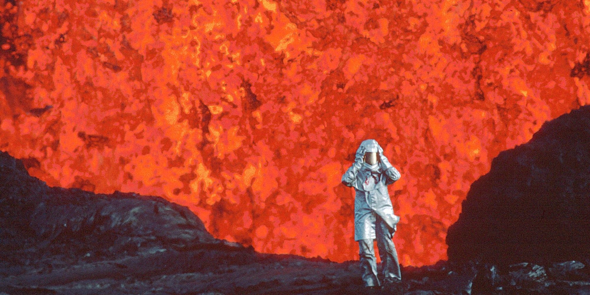 Uma pessoa em frente a uma parede de lava em Fire of Love