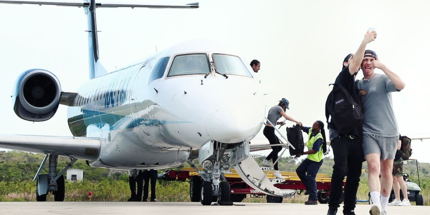 Um grupo de pessoas na frente de um avião no documentário Fyre: The Greatest Party That Never Happened