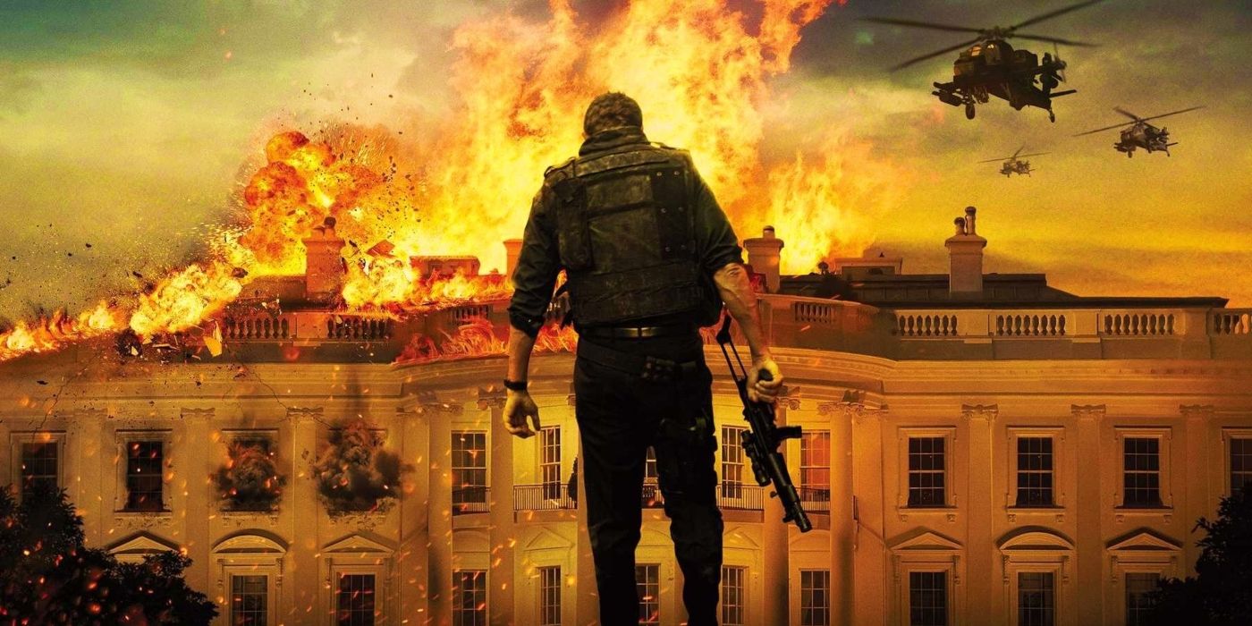 Gerard Butler as Banning holding a machine gun in front of a burning White House in Olympus Has Fallen
