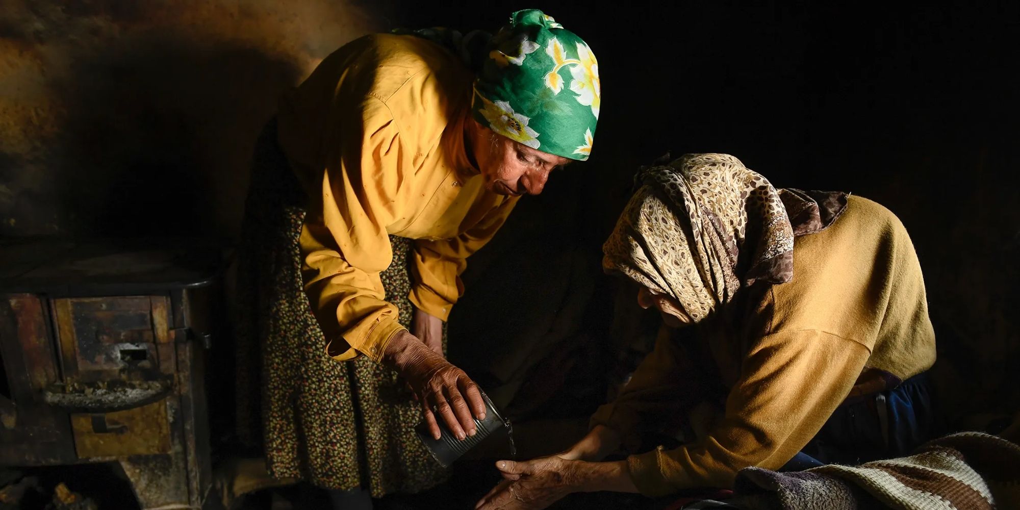 Hatidže Muratova e outra mulher derramando água em Honeyland