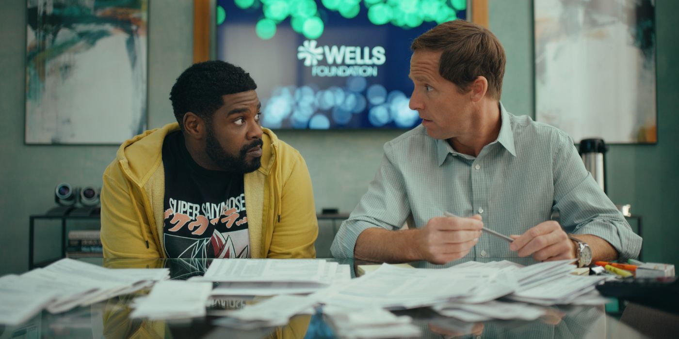 Howard (Ron Funches) and Arthur (Nat Faxon) working at a table together in “Loot” season two