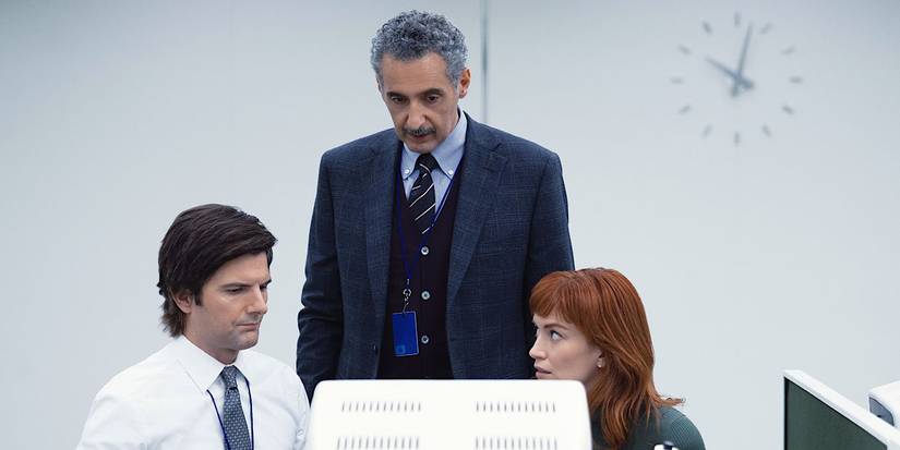 Mark and Helly sit in front of the computer while Irving stands over them in Severance. 