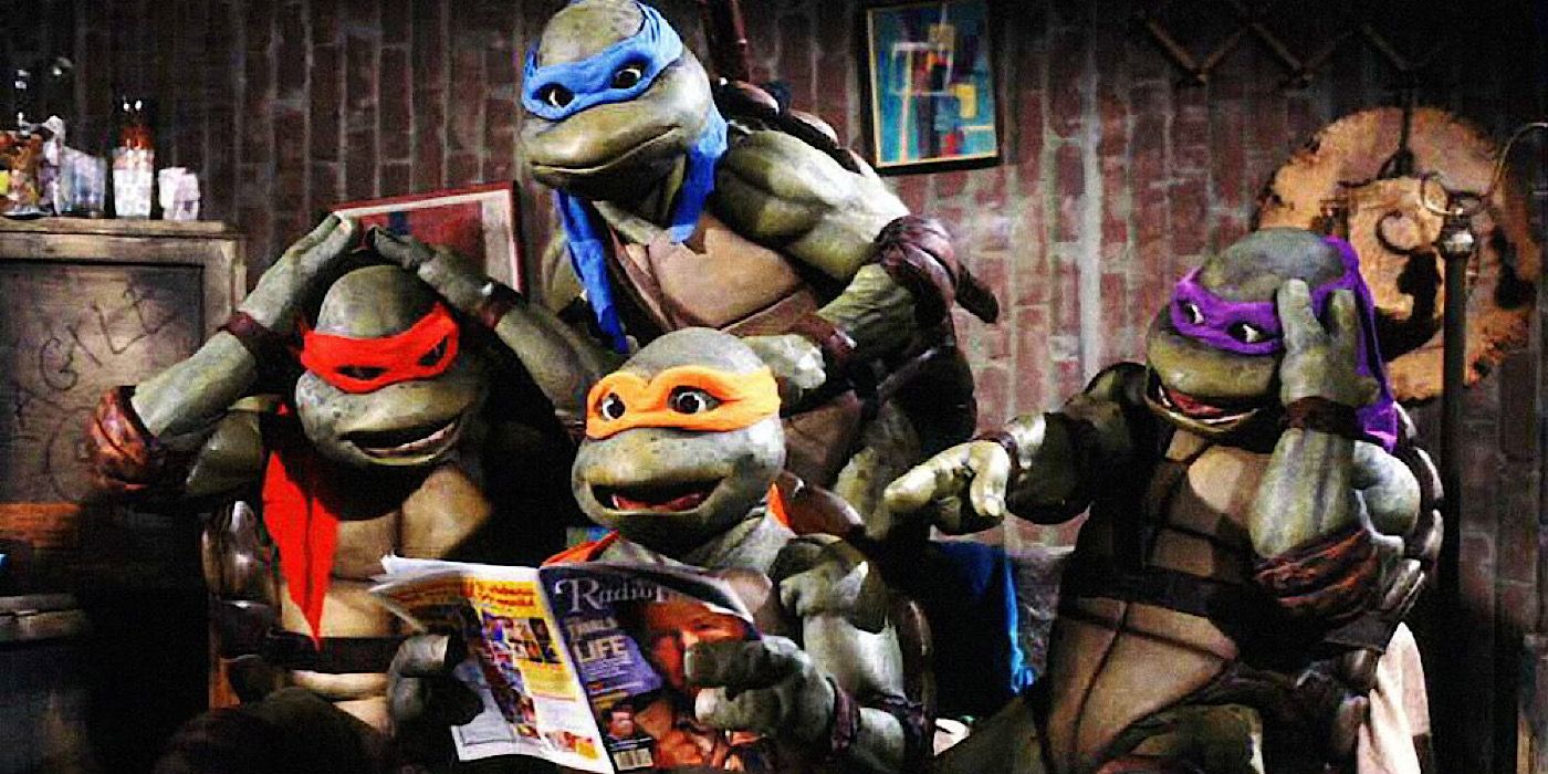 Leonardo, Donatello, Michelangelo, and Raphael are sitting on the couch and looking at a magazine in Teenage Mutant Ninja Turtles (1990)