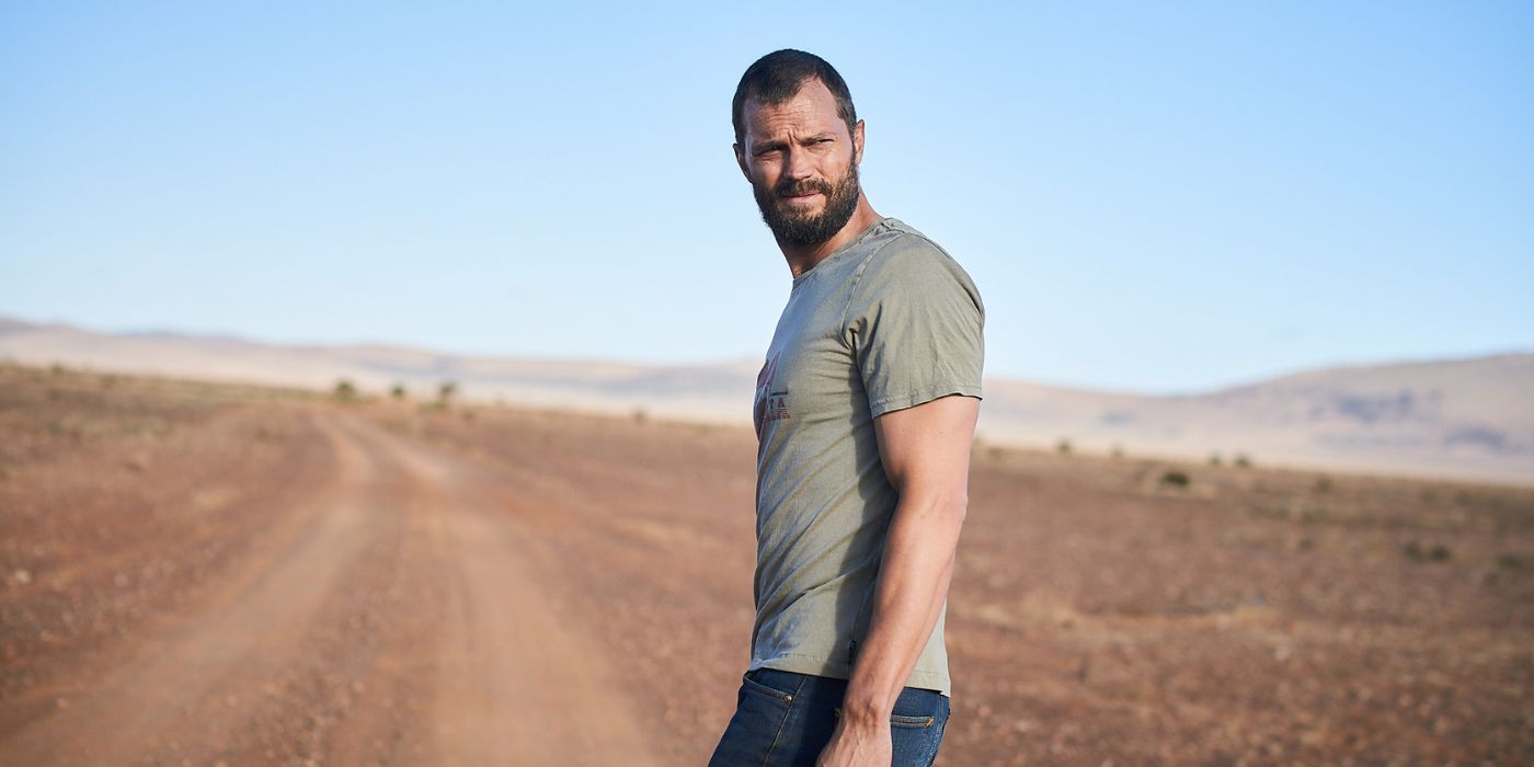 Jamie Dornan stands in the middle of a dirt road in the Outback in The Tourist season 1