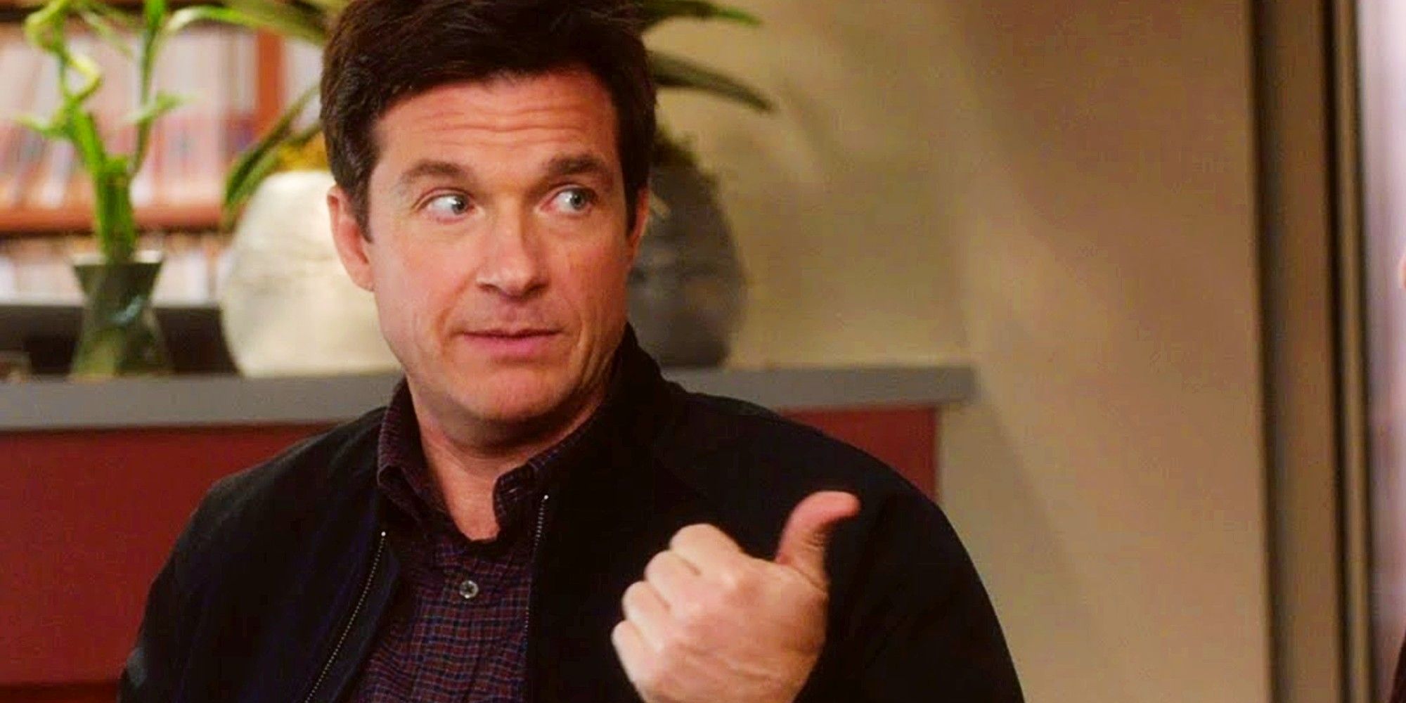 Jason Bateman giving a thumbs-up while looking off to the side in Horrible Bosses 2
