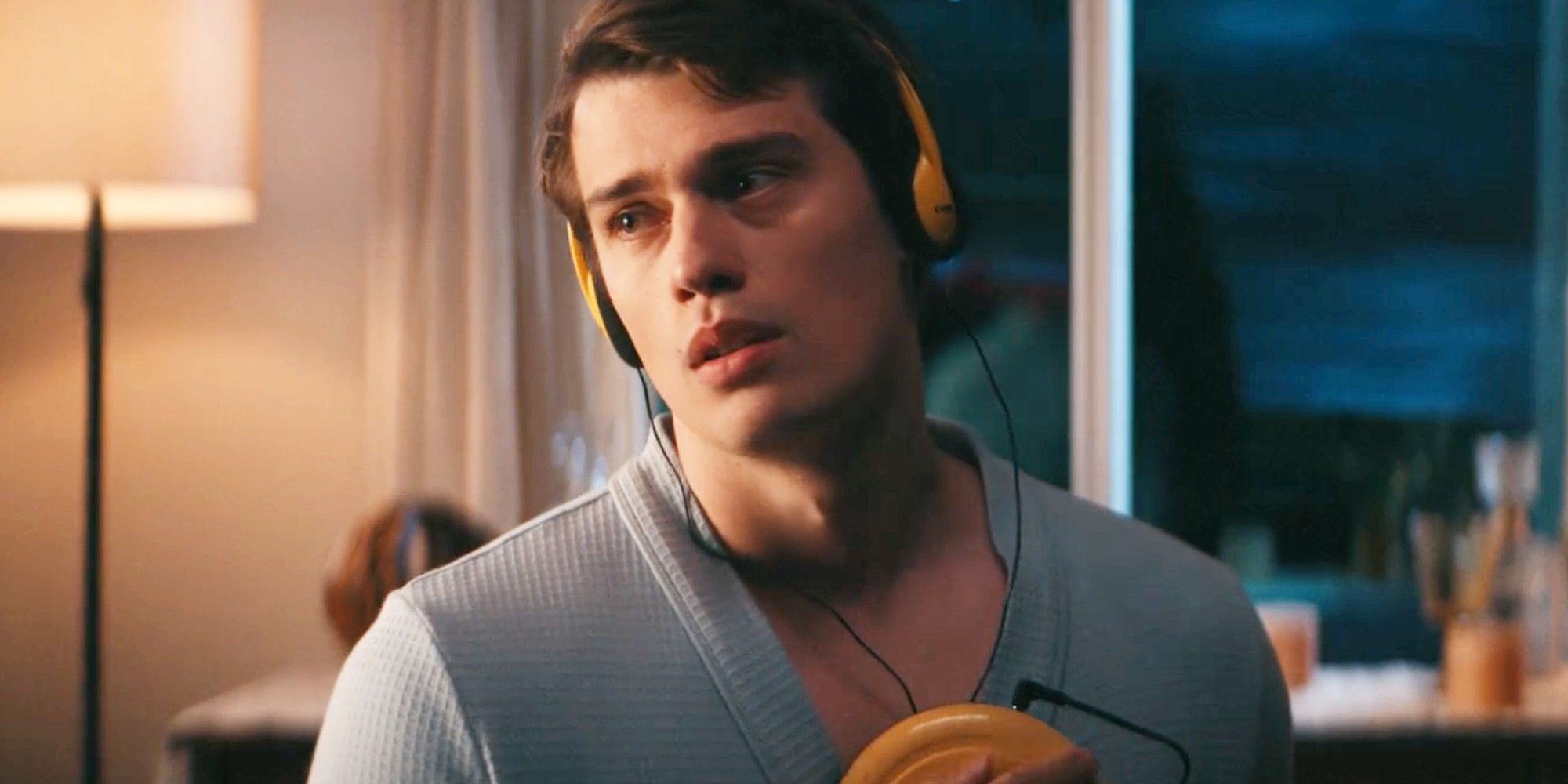Nicholas Galitzine as Jeff listens to a song on his Walkman with his wire headphones in Bottoms