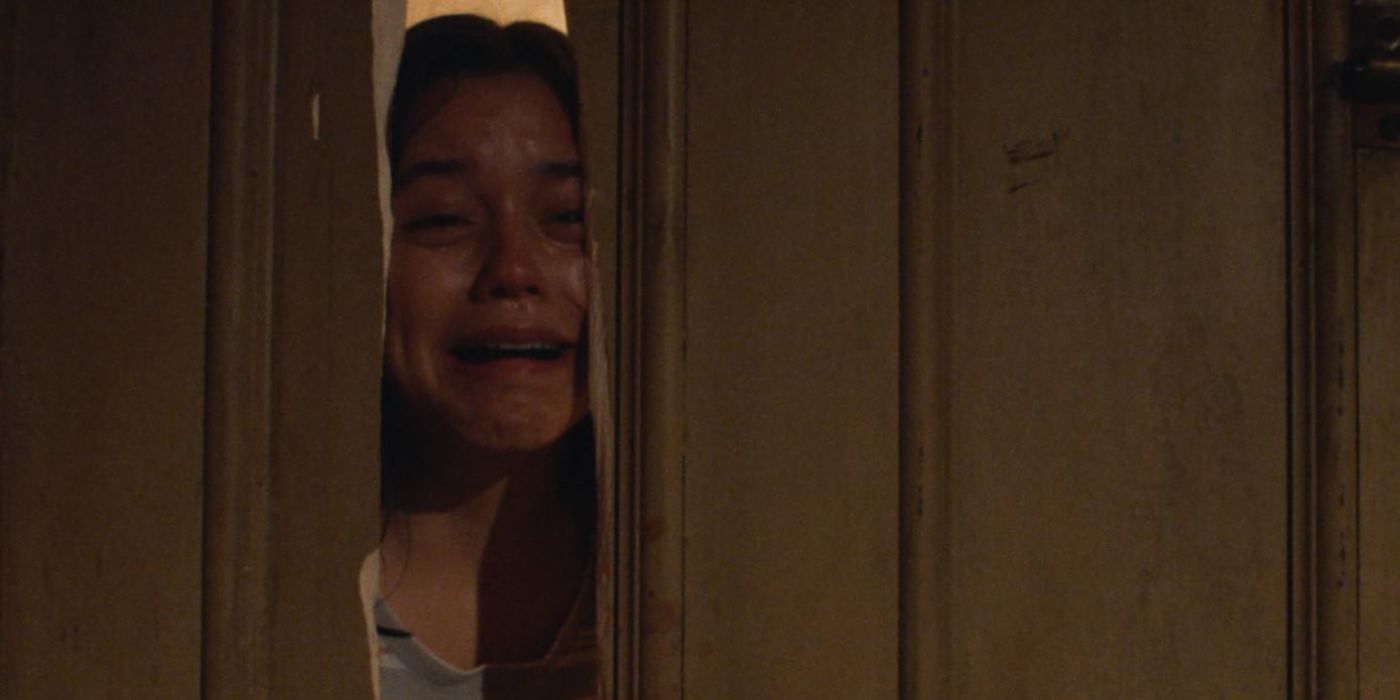 Jenna Ortega sebagai Lorraine Day menangis melalui pintu yang rusak dalam sebuah adegan dari X.