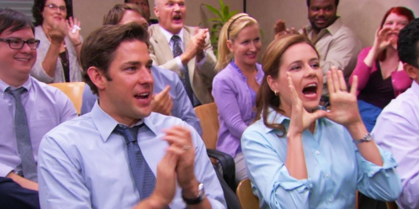 John Krasinski as Jim, Jenna Fischer as Pam, and the rest of the cast of The Office getting rowdy during a meeting 