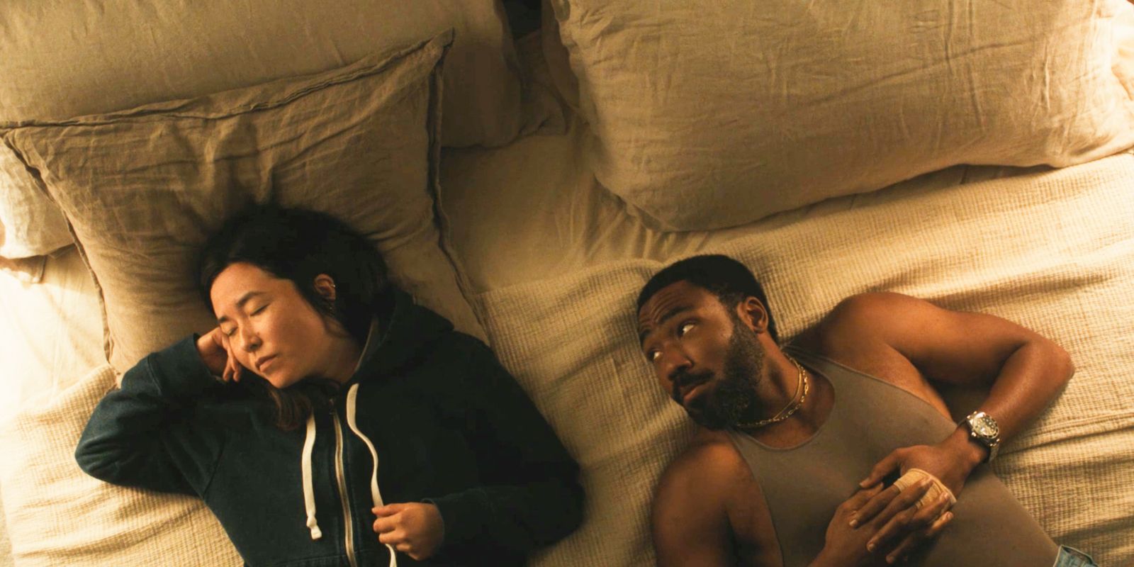 John (Donald Glover) looking over at Jane (Maya Erskine) while laying in bed in Mr. & Mrs. Smith