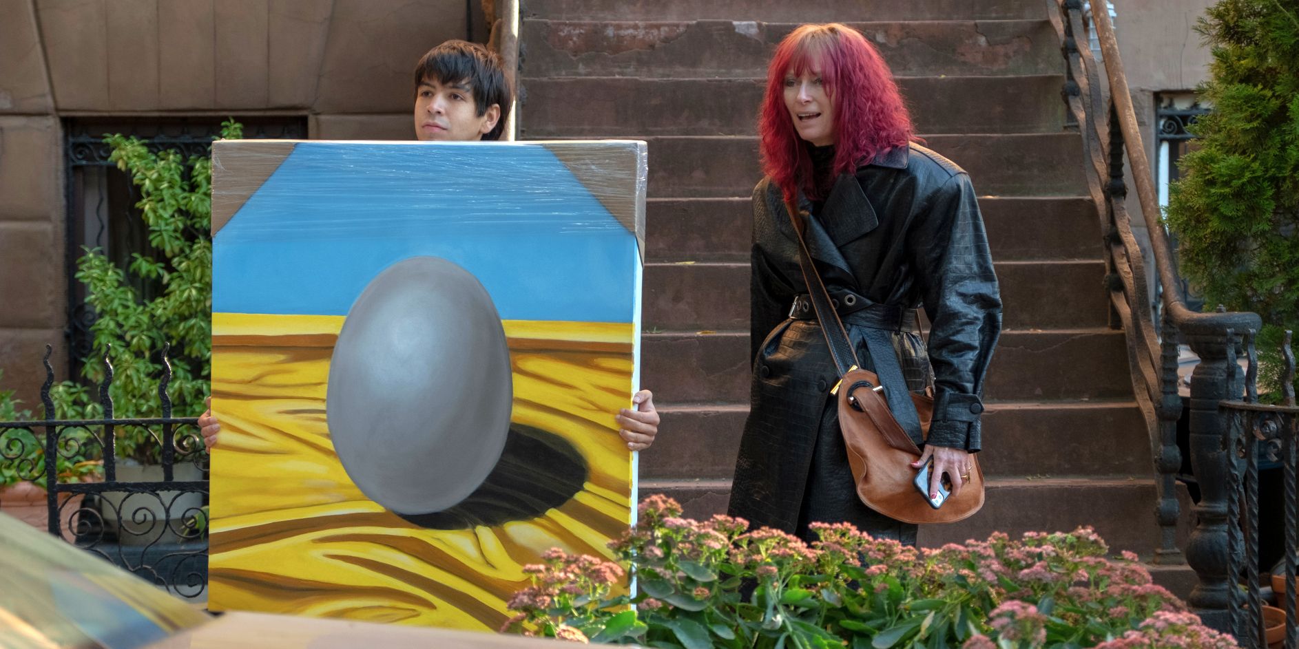 Alejandro carrying one of Bobby's egg paintings and standing next to Elizabeth in Problemista