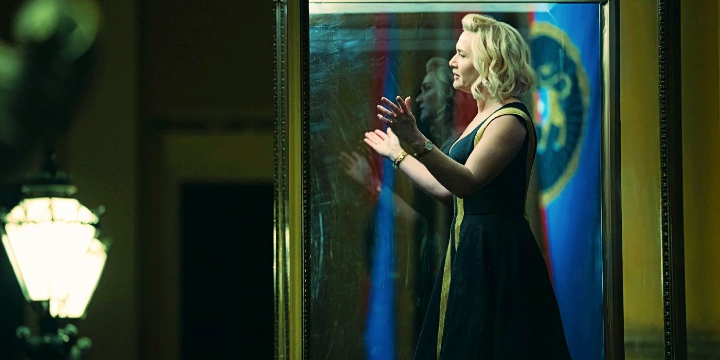 kate winslet speaks to a crowd in a glass box in the regime