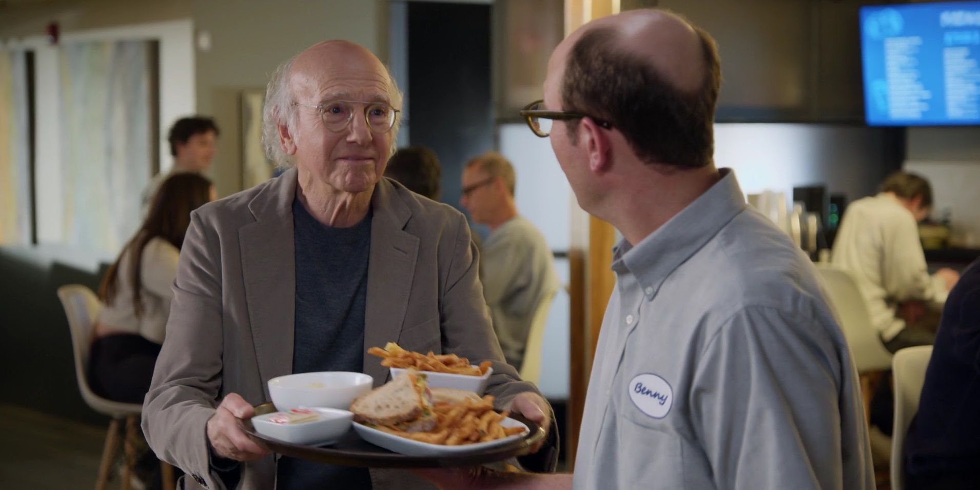 Larry pega uma bandeja de comida de um garçom em Curb Your Enthusiasm