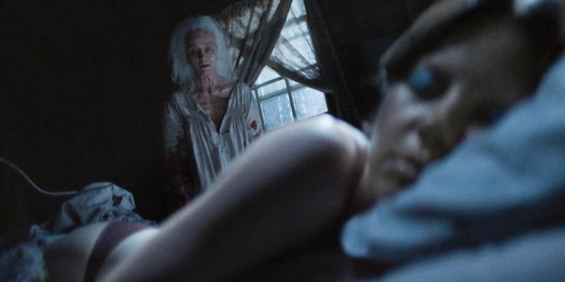 Pearl (Mia Goth) stares at Maxine (Mia Goth) while she sleeps in X.