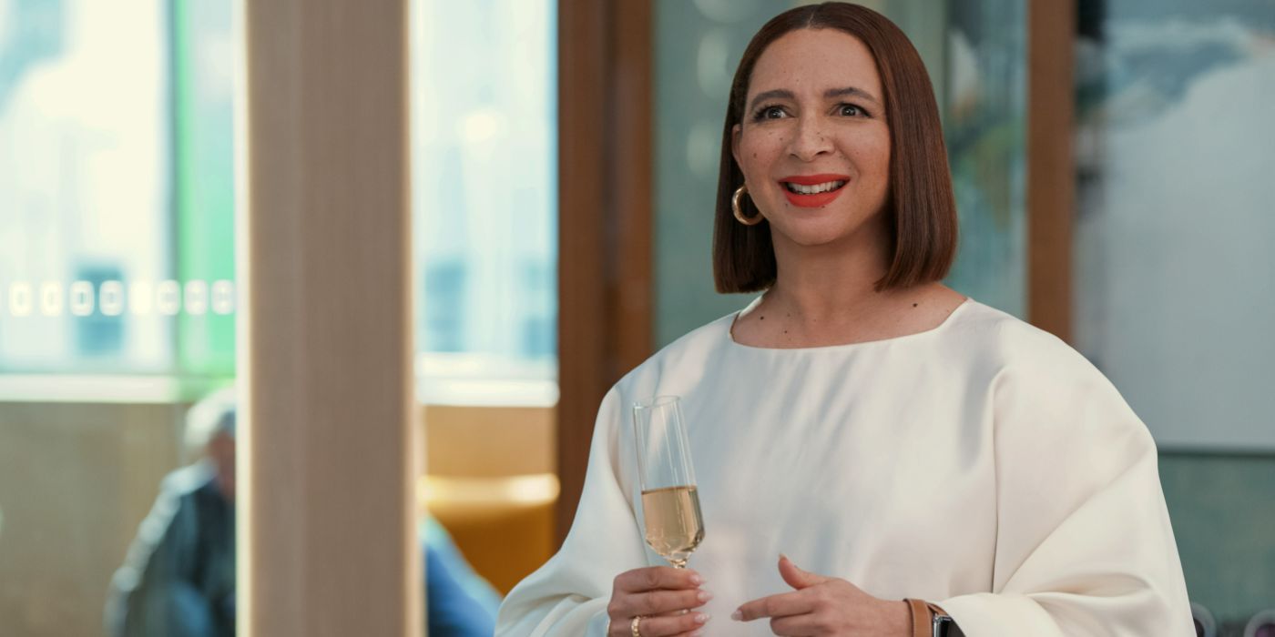 Molly (Maya Rudolph) lacht und hält ein Champagnerglas in „Loot“ der zweiten Staffel.