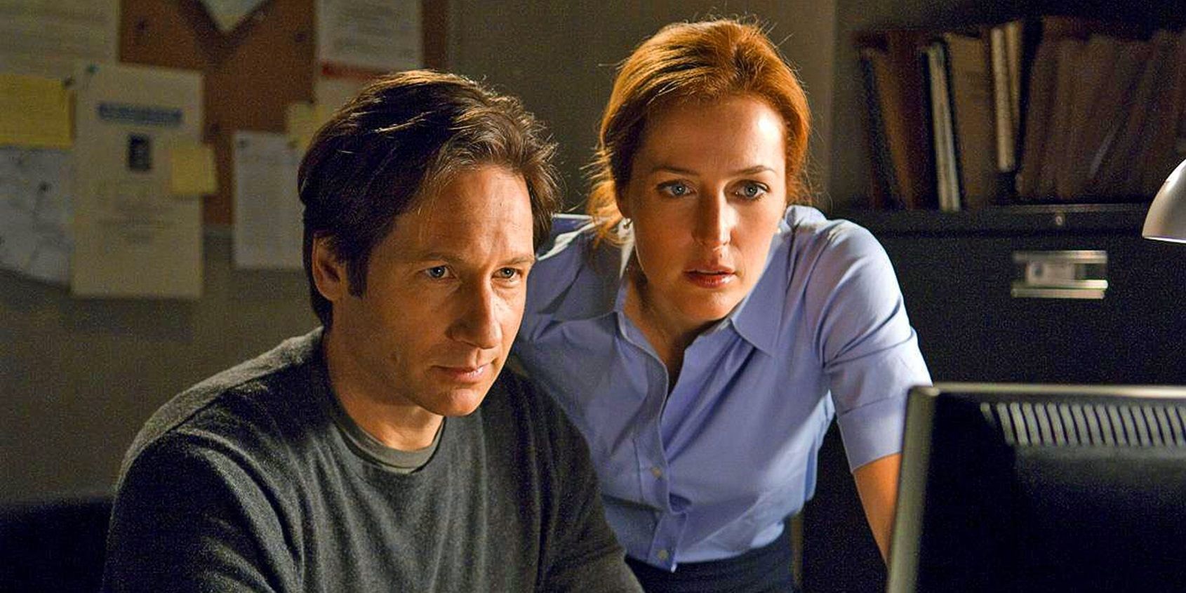 Mulder (David Duchovny) and Scully (Gillian Anderson) looking at a computer in The X-Files