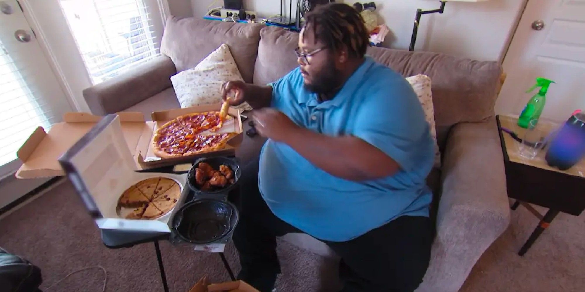My 600-lb Life Travis Henry in blue shirt on a couch