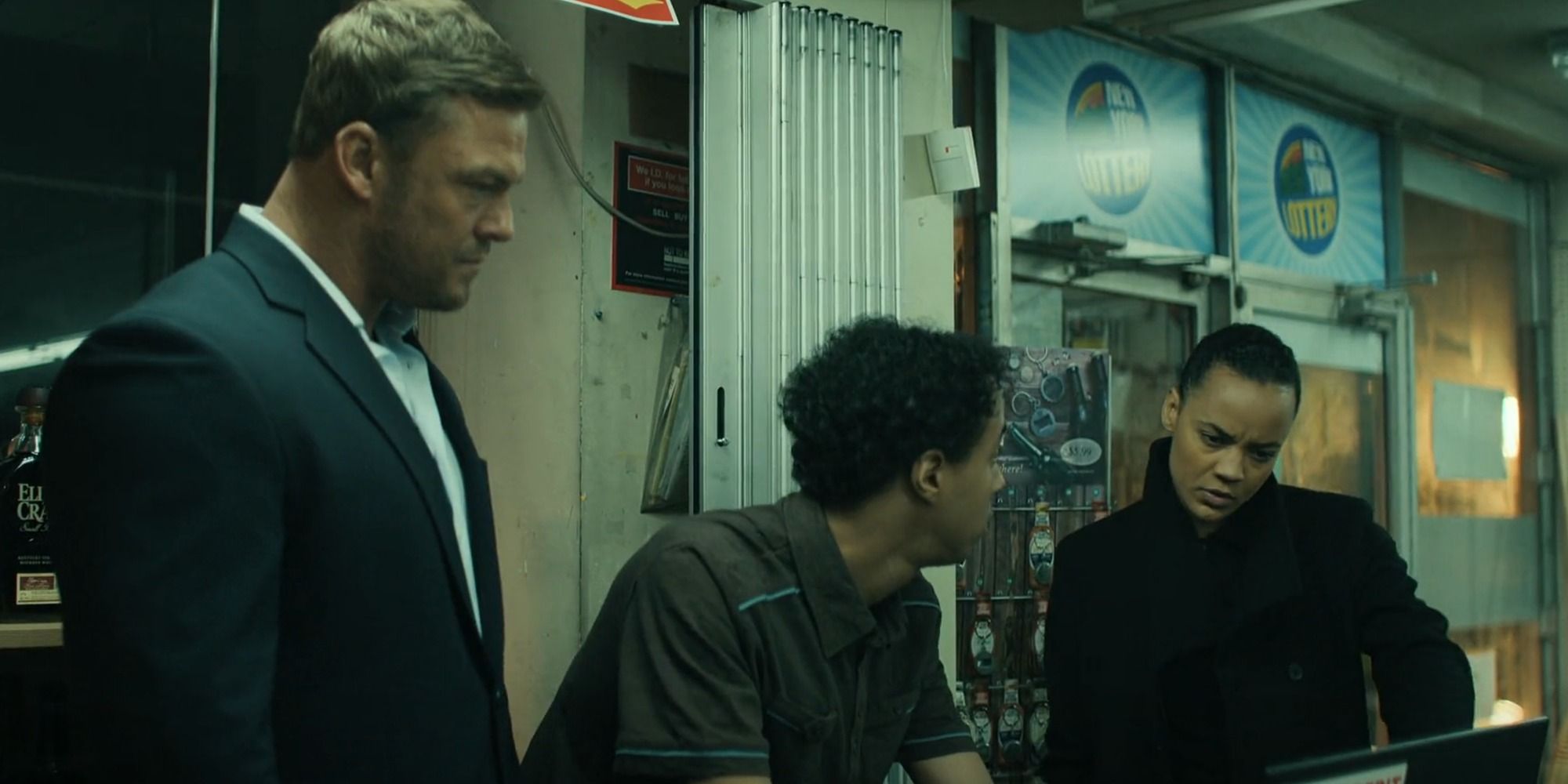 Neagley, Reacher, and the store clerk look at a computer screen in season 2, episode 6 of Reacher