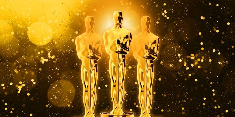 Three Oscars statues against a dark background