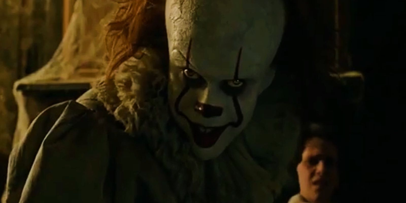 Pennywise glares while Eddie cowers in the background in IT (2017).