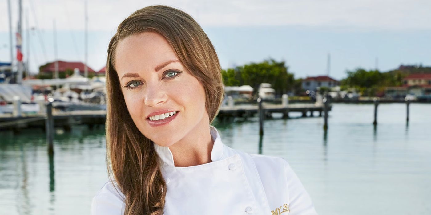 Rachel Hargrove Below Deck Smiling in her chef jacket with docks and yachts in background