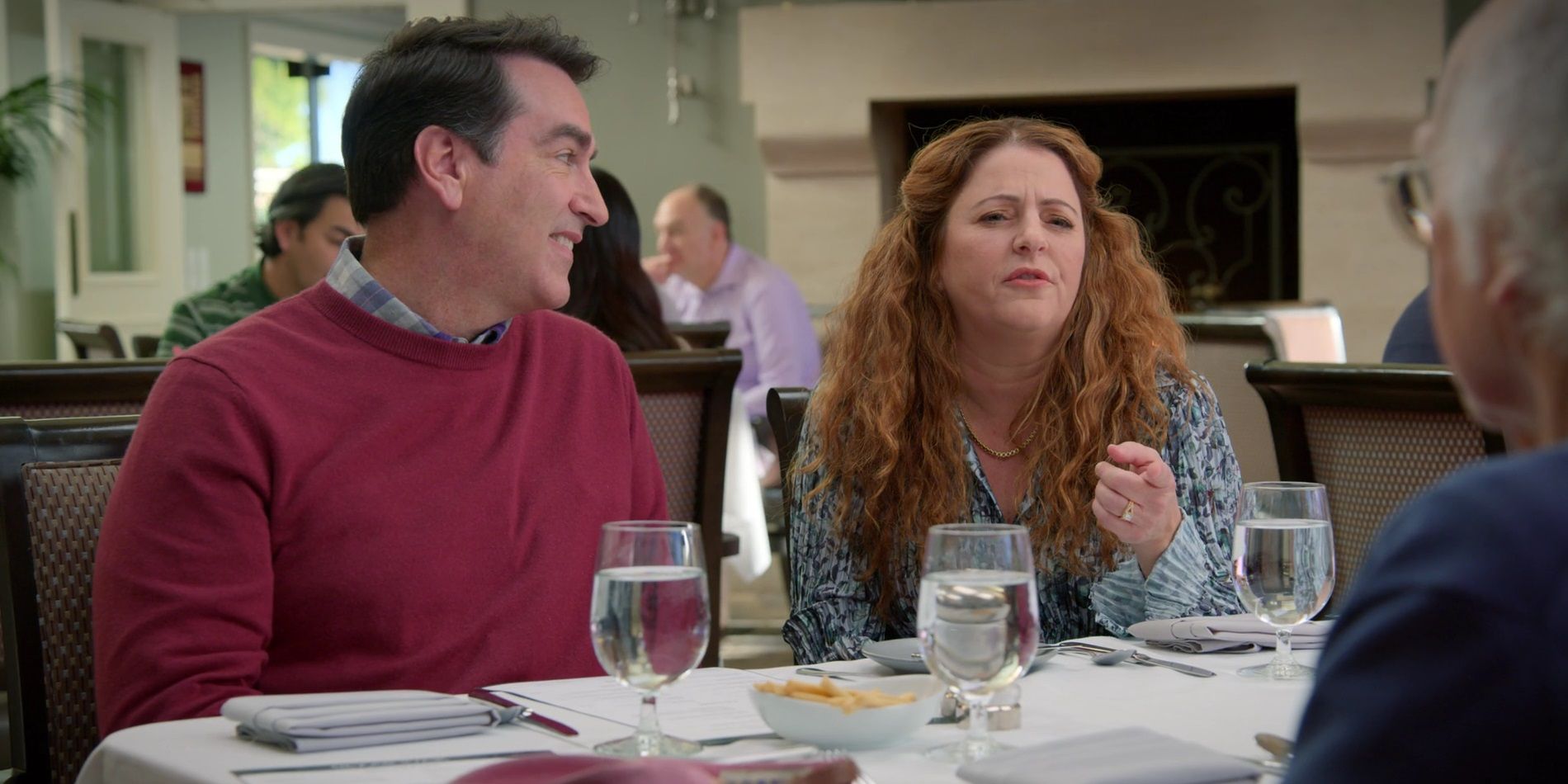 Rob Riggle e Annie Mumolo em uma mesa de jantar em Curb Your Enthusiasm-1