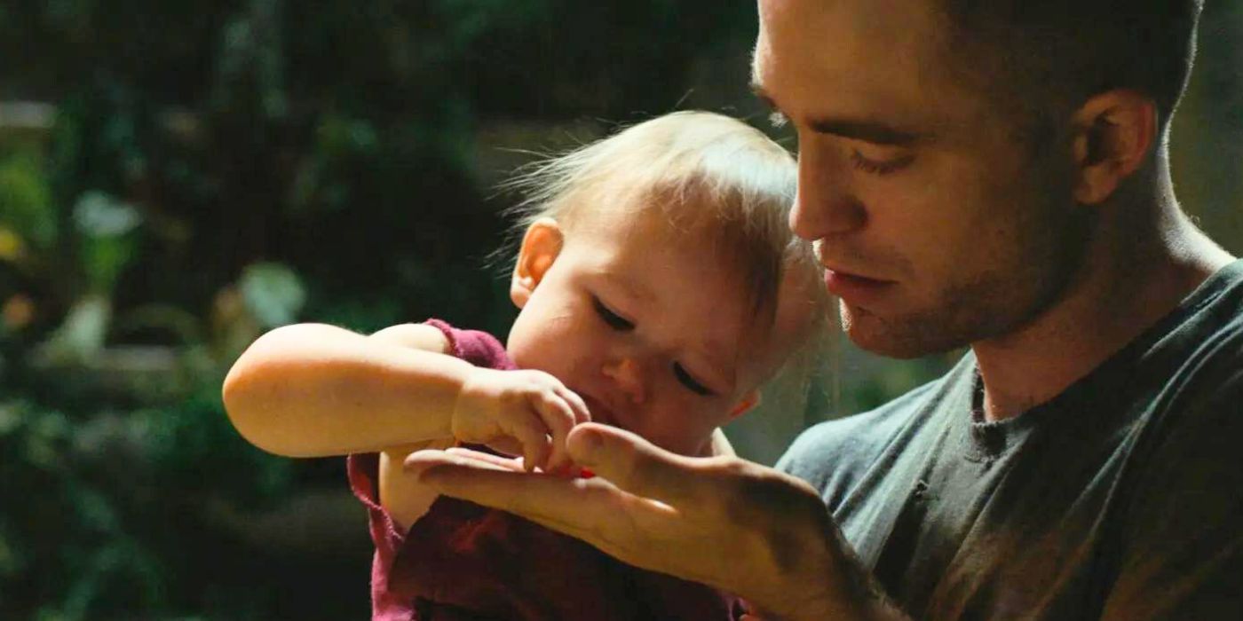 Robert Pattinson holds a child in High Life
