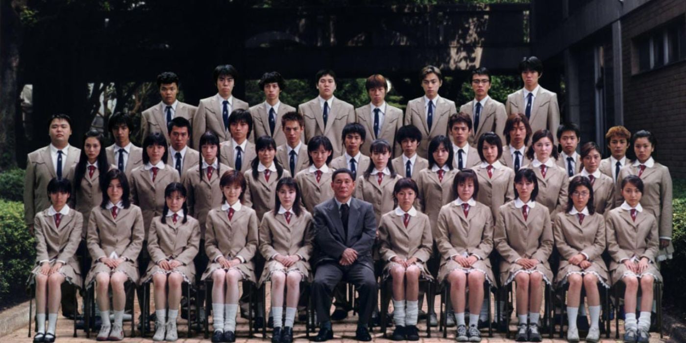 Takeshi Kitano como Kitano está no meio do elenco central de Battle Royale em Battle Royale.