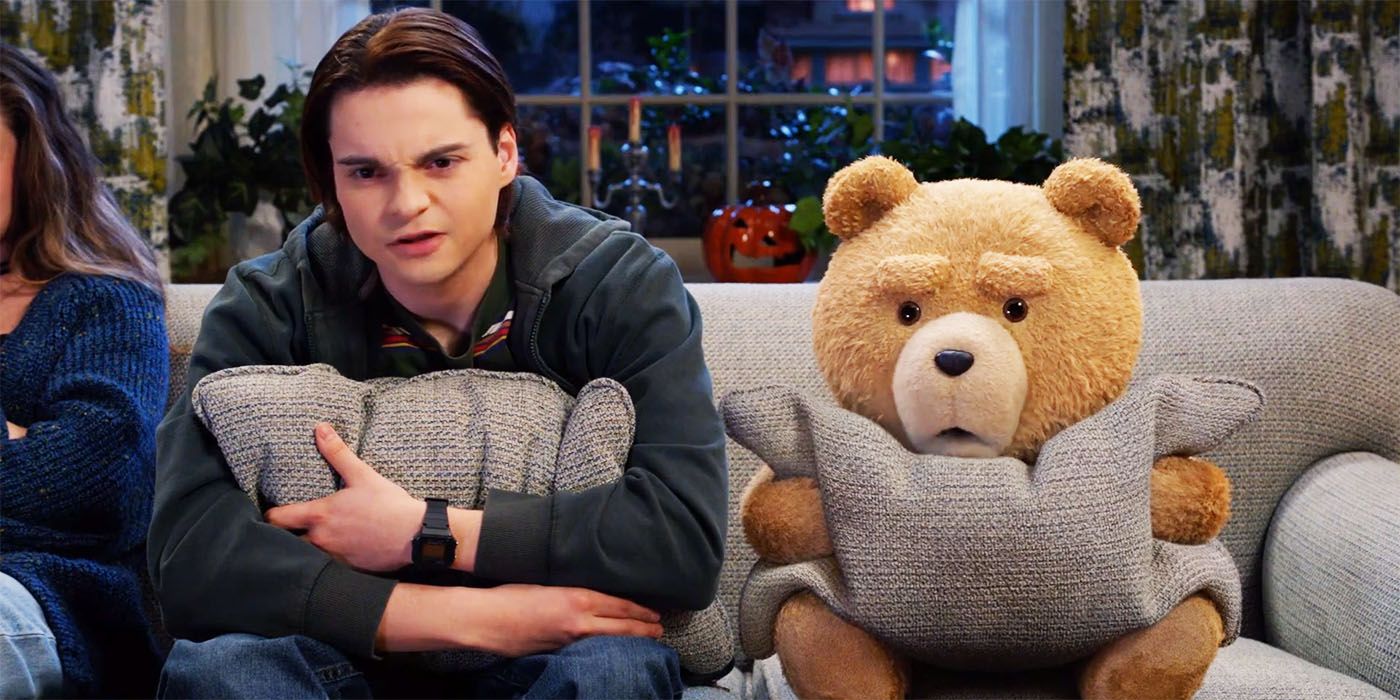 Ted and John holding pillows and sitting next to each other in the Ted prequel