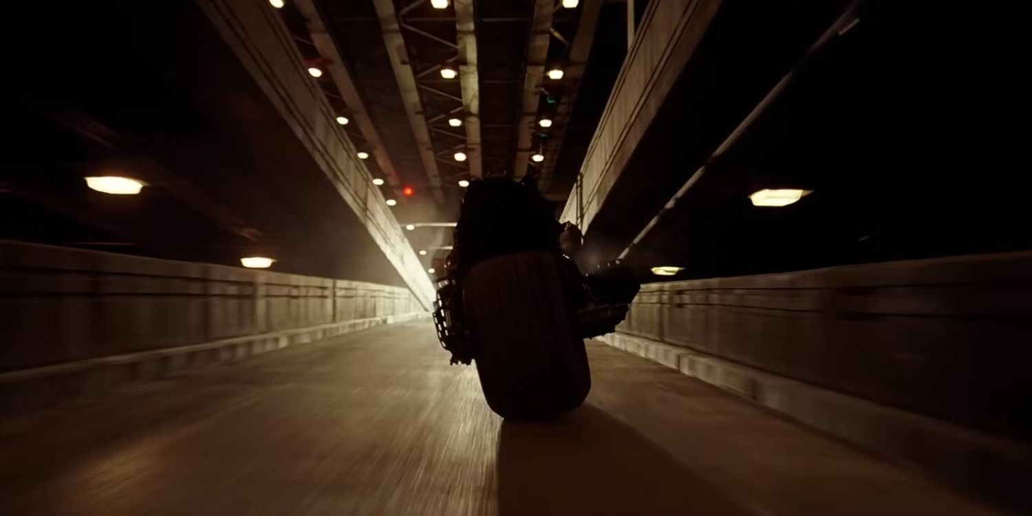 Batman, interpretado por Christian Bale, escapa no Batpod no final de O Cavaleiro das Trevas